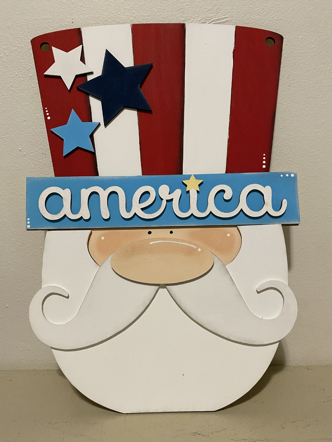 Patriotic Uncle Sam gnome door hanger painted in red, white and blue with America sign